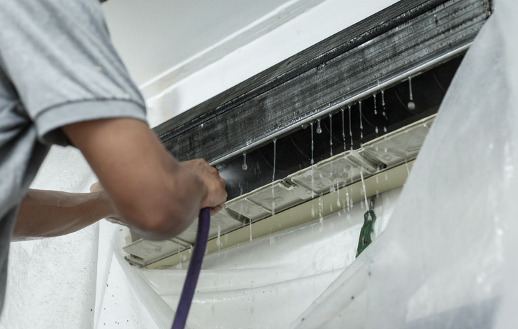 Is air conditioner water safe for pets? That's why a technician is fixing the air conditioner to avoid water dripping.