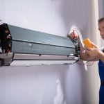 A technician is testing a air conditioner compressor.