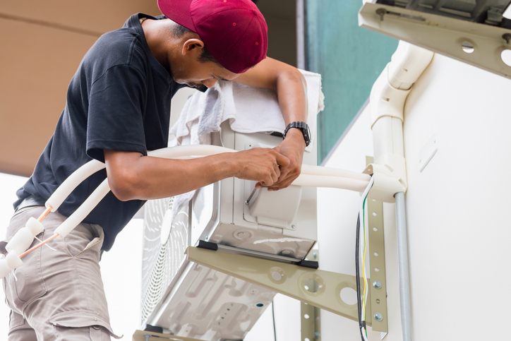 A male technician cleans the ductwork regularly to reduce allergens and dust, extending the lifespan of the HVAC system.