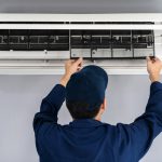 A technician performing annual maintenance to identify and fix issues such as clogged filters, refrigerant leaks, broken fans, etc.