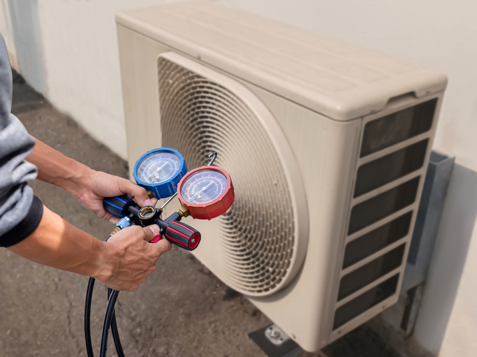An HVAC professional performing a seasonal tune-up to show how HVAC systems control humidity effectively.