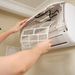 Technician performing professional maintenance on mold removal HVAC system.