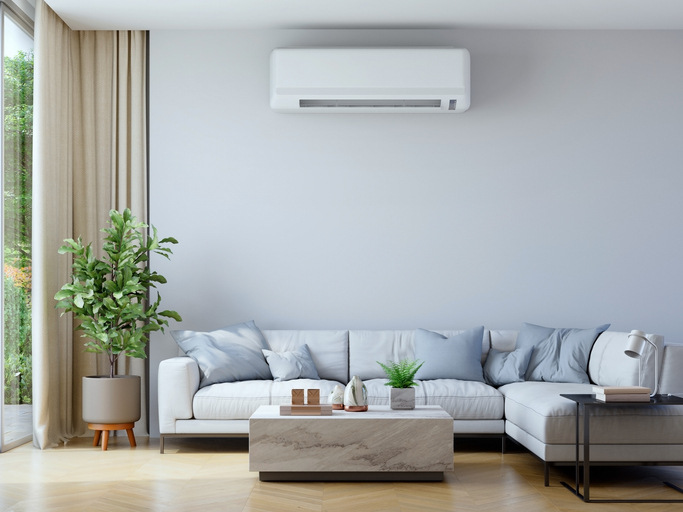 Modern living room featuring a white ductless mini-split HVAC unit, illustrating how long HVAC systems last in Arizona with proper maintenance.
